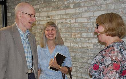 Dr. Doug Baker and his wife, Linda, laugh with English Associate Professor Jennifer Poynter-Thompson.