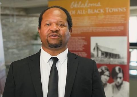 Dr. Steven Collins stands in front of the All-Black Towns of Oklahoma display on the second floor of the Student Center at OSU-OKC. (Ned Wilson) 