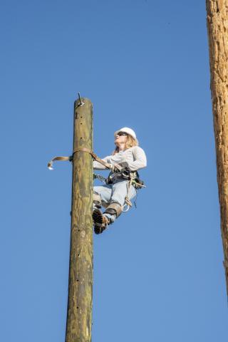 Student climbs electric pole as part of PTDT instruction at OSU-OKC. 