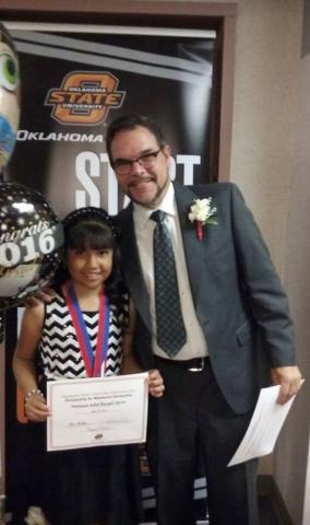Dayanna Rangel-Meraz receives a scholarship certificate in sixth grade. 